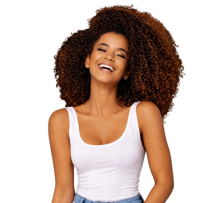 A young woman with curly hair smiling and wearing a white tank top.